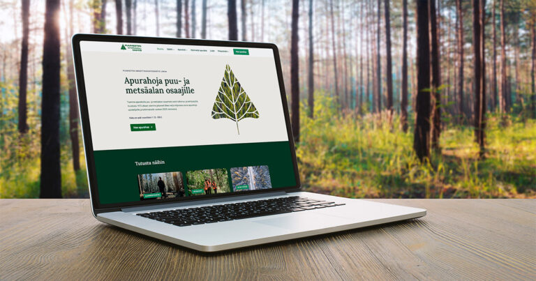 Puumiesten Ammattikasvatussäätiön uudet verkkosivut kannettavalla tietokoneella, taustalla metsää.